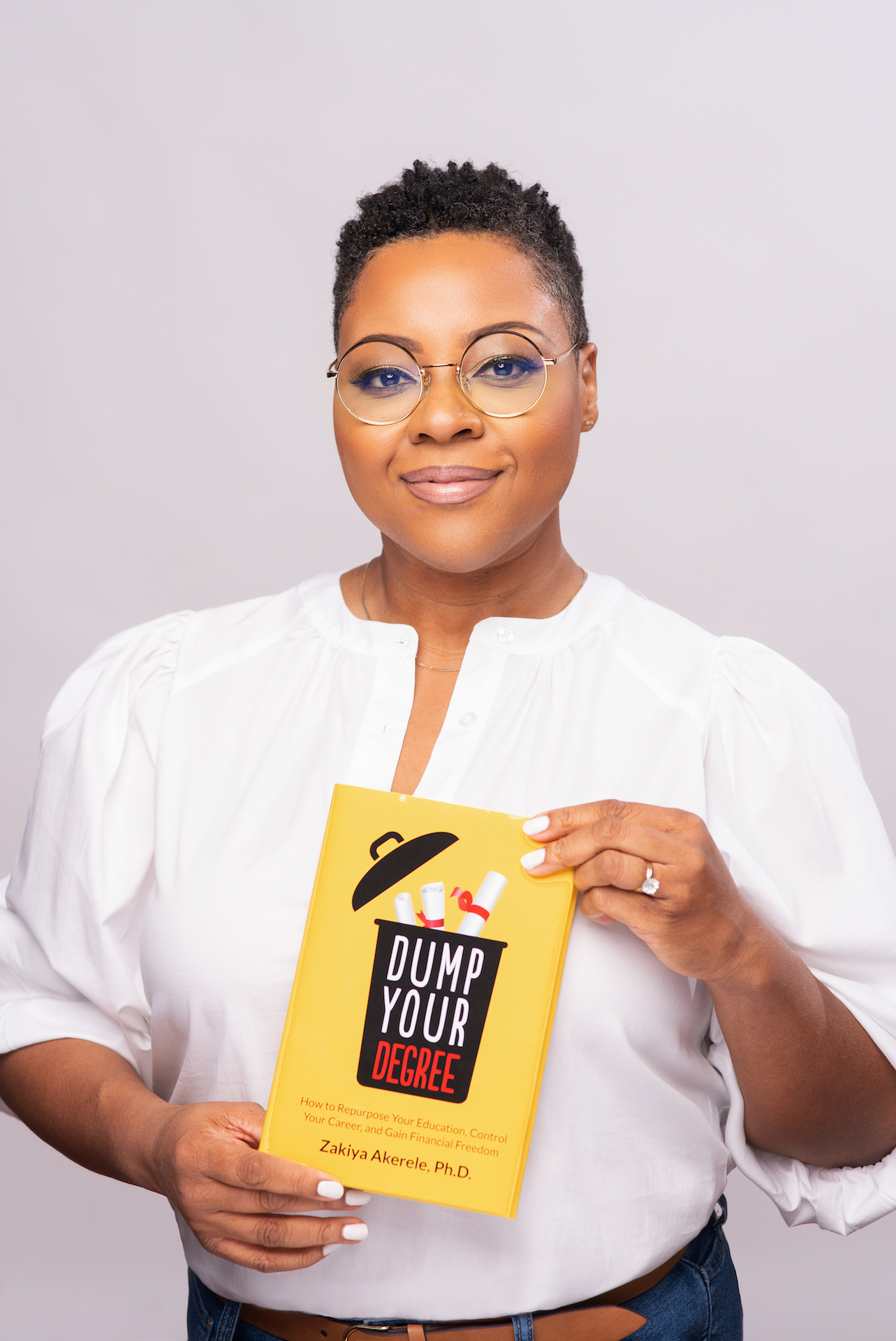 Zakiya Akerele holding her book Dump Your Degree
